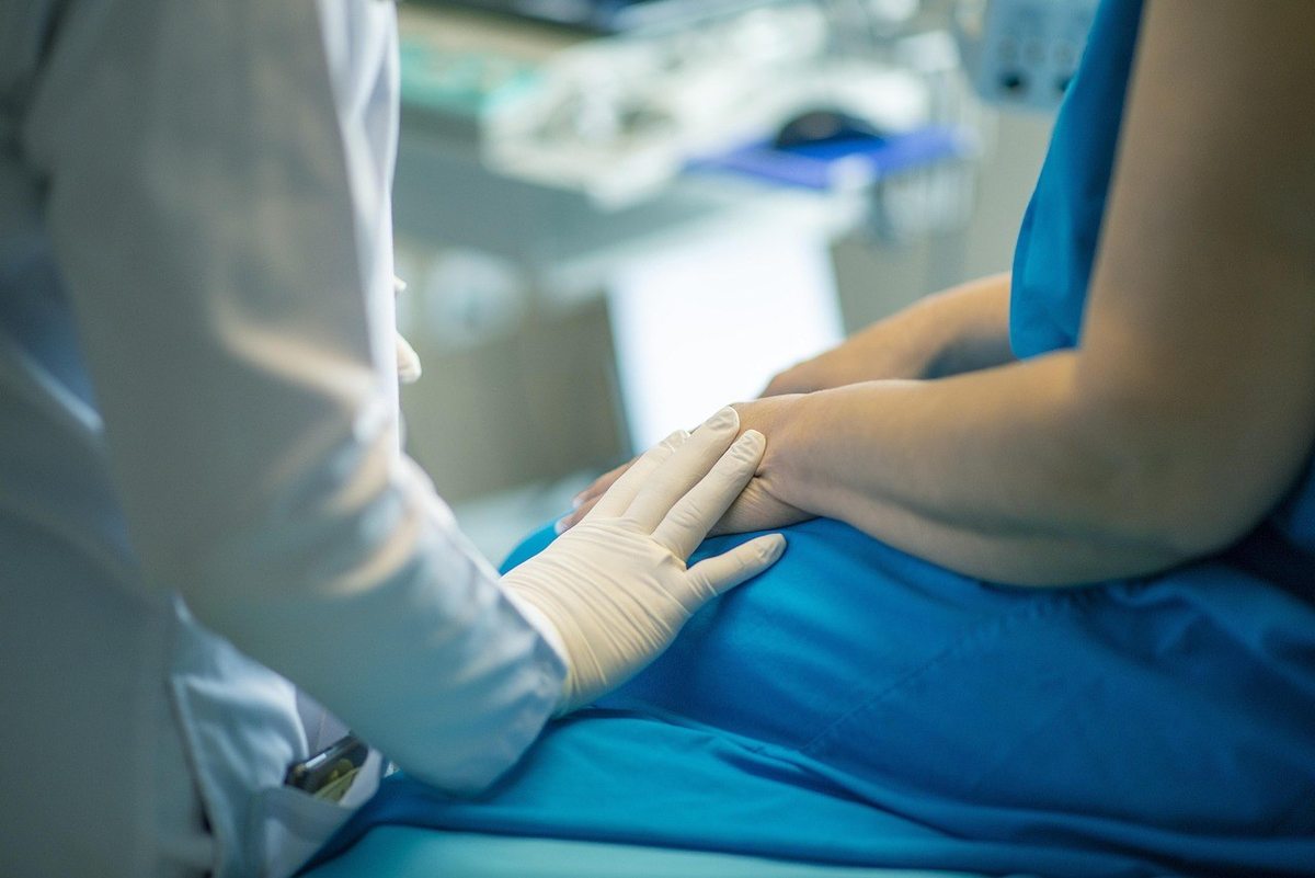 Examen abdominal par un médecin sur une patiente dans un cadre médical