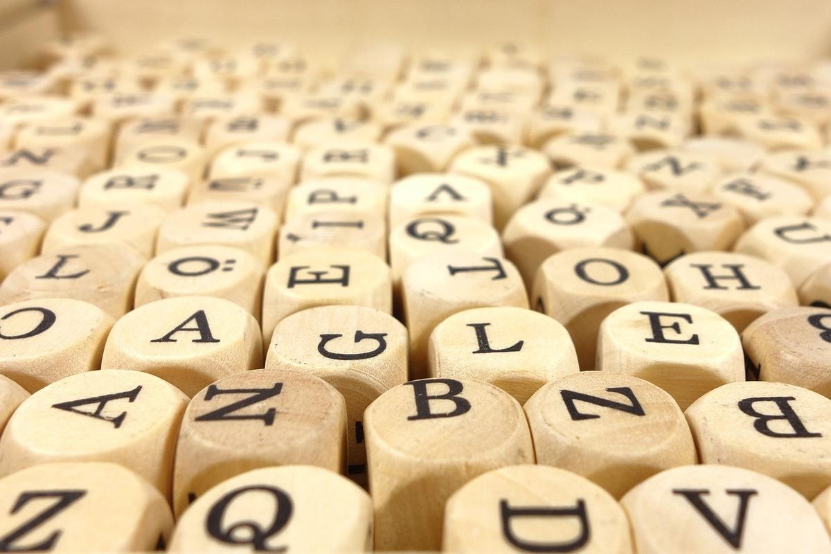 Carrés en bois avec lettres noires, semblables à des briques, formant un ensemble Carrés en bois avec lettres noires, semblables à des briques, formant un ensemble