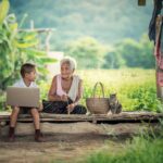 Un jeune garçon utilise un ordinateur portable à côté d'une grand-mère