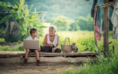 Un jeune garçon utilise un ordinateur portable à côté d'une grand-mère
