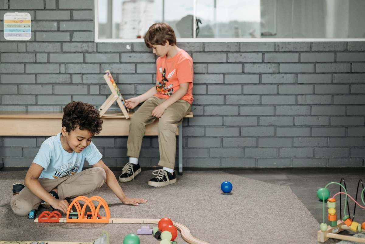 Enfants jouant avec des jouets, un garçon lit, tapis, briques, jouets épars Enfants jouant avec des jouets, un garçon lit, tapis, briques, jouets épars