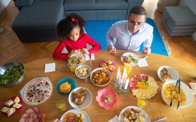 Famille partageant un repas de pâques avec divers plats sur une table en bois dans un salon