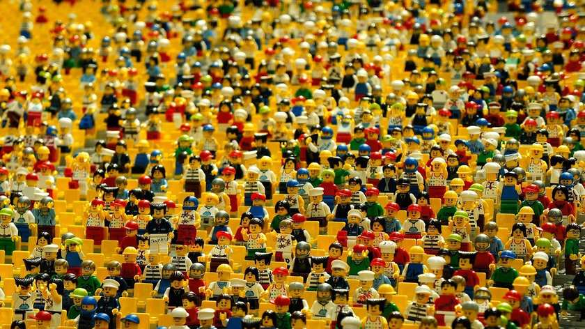 Collection dense de minifigurines Lego assises, couleurs variées, disposition uniforme Collection dense de minifigurines Lego assises, couleurs variées, disposition uniforme