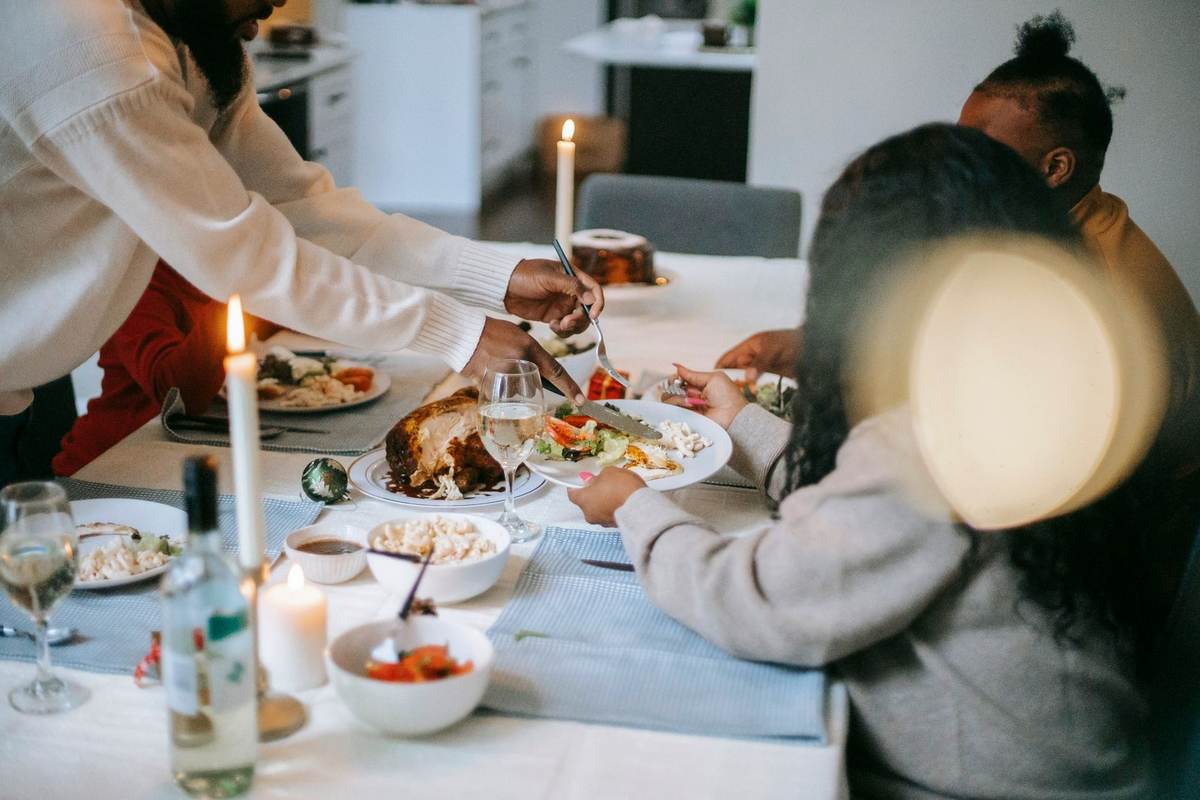 Famille réunie autour d'un repas, bougies et plats sur la table dans un salon Famille réunie autour d'un repas, bougies et plats sur la table dans un salon