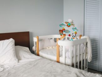 Lit et berceau dans une chambre d'enfant avec jouets et rideaux