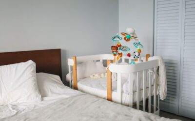 Lit et berceau dans une chambre d'enfant avec jouets et rideaux