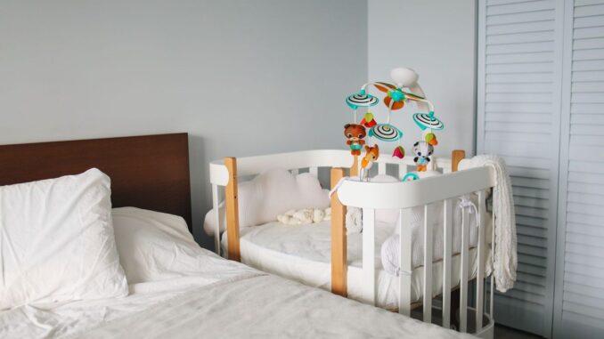 Lit et berceau dans une chambre d'enfant avec jouets et rideaux