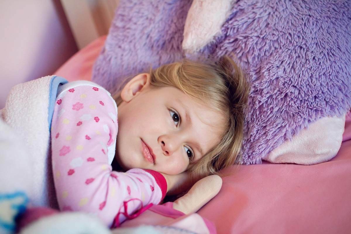 Fille couchée avec un grand nounours violet Fille couchée avec un grand nounours violet