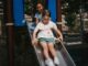 Enfants sur une glissière dans un parc, structures bleues et végétation environnante