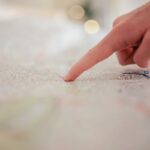 Une main indique un point précis sur une carte détaillée