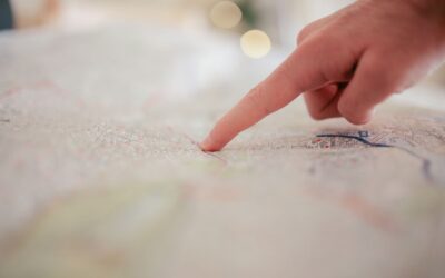 Une main indique un point précis sur une carte détaillée