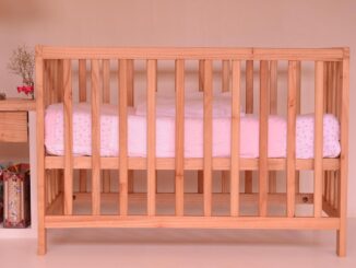 Un berceau en bois avec un matelas blanc et rose