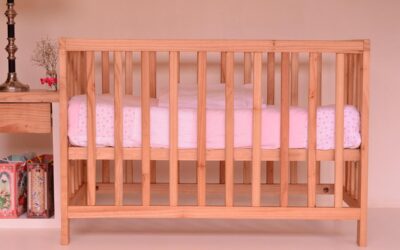 Un berceau en bois avec un matelas blanc et rose